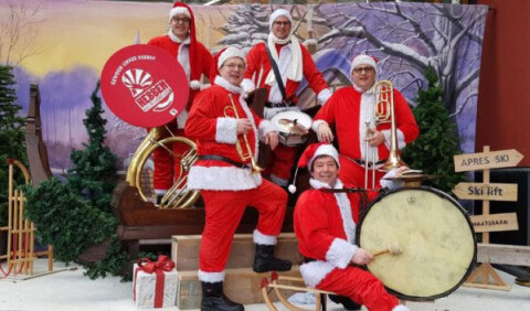 Band met kerstmannen die kerstmuziek maken in Dorpshart Lisse
