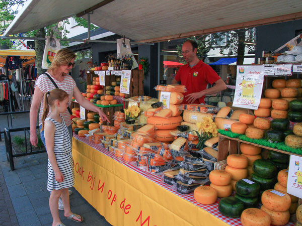 Moeder en dochter bij kraam op de markt met kaas in Lisse tijdens de corsomarkt